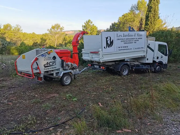 Broyeur de végétaux attelé au camion-benne de l’entreprise, dans une pinède