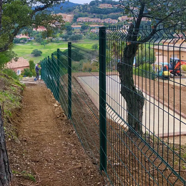 Panneaux rigides verts posés sur un talus, collines en fond